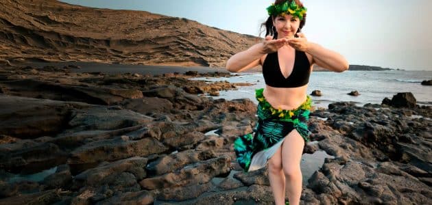 Mujer bailando danza tahitiana en la playa